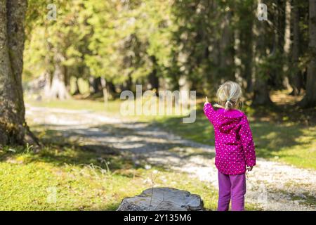 Adorable petite fille en randonnée dans la nature sur une belle journée d'automne montrant et doigt sur le chemin Banque D'Images