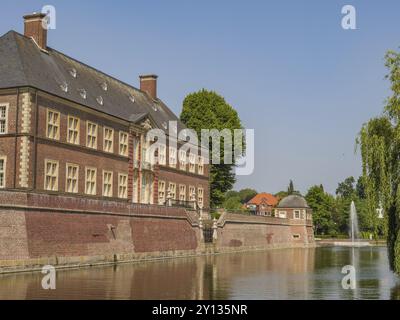 Grand château en briques avec douves et fontaine dans un cadre verdoyant, ahaus, muensterland, allemagne Banque D'Images