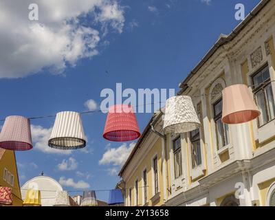 Abat-jour suspendus colorés entre les bâtiments sous un ciel nuageux, szentendere, Danube, Hongrie, Europe Banque D'Images