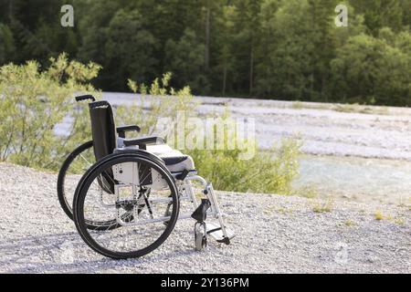 Fauteuil roulant vide debout dans un parc sur le chemin de marche Banque D'Images