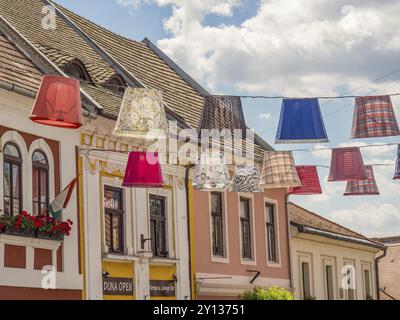 Des abat-jour colorés surplombent une rue pittoresque avec des bâtiments historiques et des toits de tuiles, esztergom, danube, hongrie Banque D'Images