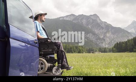 Ascenseur électrique véhicule spécialisé pour les personnes handicapées. Fauteuil roulant vide sur une rampe avec nature et montagnes à l'arrière Banque D'Images