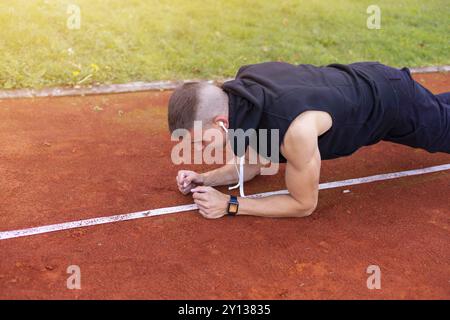 Jeune homme planche faisant de l'exercice dans la piscine le matin sur la piste de course course Banque D'Images