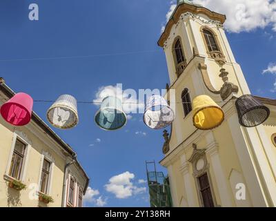 Abat-jour colorés suspendus au-dessus d'une rue près d'une église sous un ciel bleu, esztergom, danube, hongrie Banque D'Images