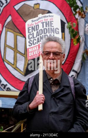 Un manifestant assiste à une manifestation appelant à la justice après la publication du rapport d'enquête sur l'incendie de la tour Grenfell. Banque D'Images