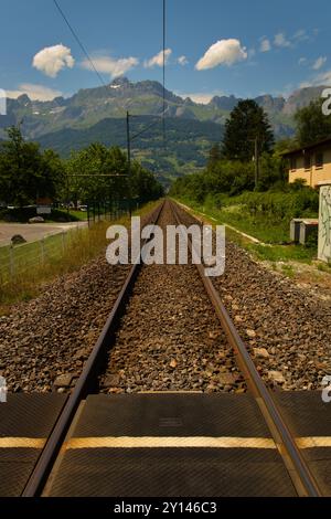 Chemin de fer dans le paysage alpin avec fond de chaîne de montagnes. Banque D'Images