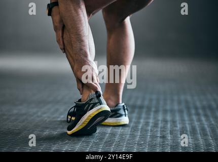 Fitness, homme et douleur de cheville de blessure d'entraînement avec accident d'entraînement, tension musculaire et entorse au gymnase. Sport, ecchymose d'athlète et urgence médicale Banque D'Images