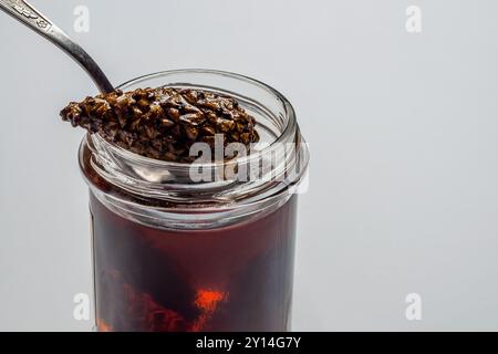 Sirop de pomme de pin, servi avec une cuillère et du miel, un remède traditionnel et une friandise sucrée. Banque D'Images