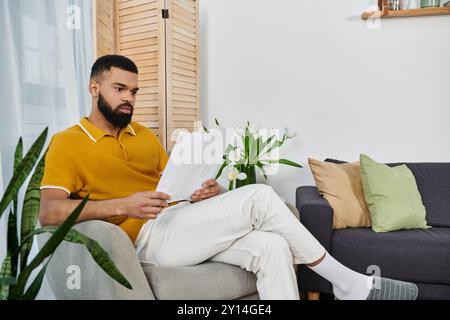 Un homme détendu aime le temps libre à la maison, lisant des documents importants. Banque D'Images