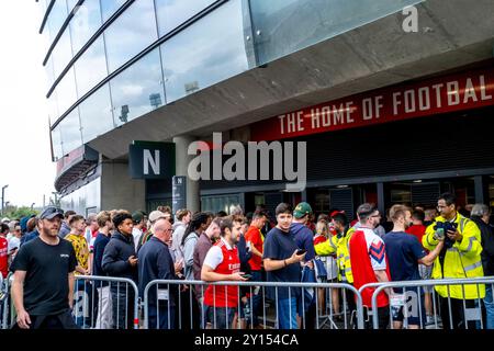 Les fans de football d'Arsenal font la queue pour Un contrôle de sécurité avant d'entrer dans l'Emirates Stadium, Londres, Royaume-Uni. Banque D'Images