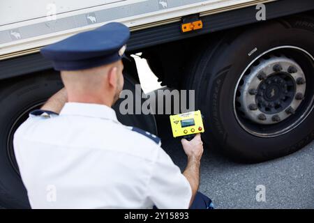 Burghausen, Allemagne. 05th Sep, 2024. Un policier de la police des frontières bavaroise utilise un soi-disant dispositif de détection de personnes pour vérifier si des personnes sont cachées dans la semi-remorque d'un camion lors d'un événement de presse à un point de contrôle. Le dispositif de détection de personne peut détecter des vibrations minimes dans un véhicule. Lors de la conférence de presse, des informations seront fournies sur la situation actuelle aux frontières bavaroises avec l'Autriche et la République tchèque, ainsi que sur les mesures visant à renforcer la protection des frontières. Crédit : Matthias Balk/dpa/Alamy Live News Banque D'Images