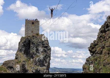 Rovensko pod Troskami, République tchèque - 28 juillet 2024 : marcheur de corde raide entre les deux tours de la ruine historique tchèque Troski Banque D'Images