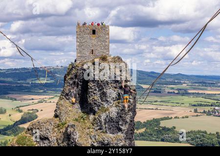 Rovensko pod Troskami, République tchèque - 28 juillet 2024 : marcheur de corde raide entre les deux tours de la ruine historique tchèque Troski Banque D'Images