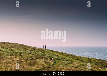 Deux personnes marchant le long d'une piste sur Pwhole point East sur la côte de Newquay en Cornouailles au Royaume-Uni, en Europe. Banque D'Images