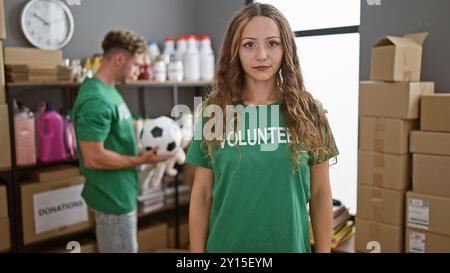 De jeunes bénévoles, femmes et hommes, trient les dons à l'intérieur d'un centre, mettant en valeur le service communautaire et le travail d'équipe. Banque D'Images