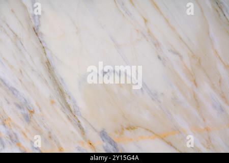 Texture en marbre veiné doré avec des teintes blanches et grises douces pour une utilisation intérieure. Banque D'Images