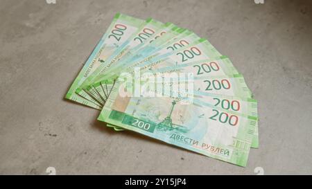 Billets de banque en rouble russe disposés en éventail sur une surface en béton, mettant l'accent sur les thèmes monétaires et financiers. Banque D'Images