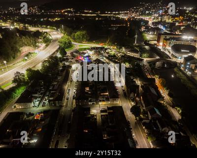 Vue aérienne d'une autoroute traversant une petite ville du pays de galles, éclairée par des lampadaires la nuit Banque D'Images