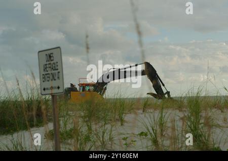 Commencez Pete Beach, FL vers le Golfe du Mexique alors que les machines lourdes travaillent sur la nourriture de plage . Vue sur le sable et l'avoine de mer. Un jour nuageux tard dans l'après Banque D'Images