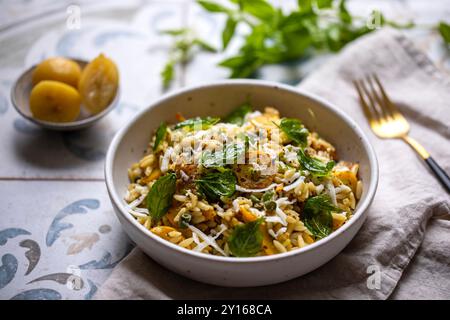 Pâtes Orzo à la courgette jaune, citron conservé et basilic Banque D'Images