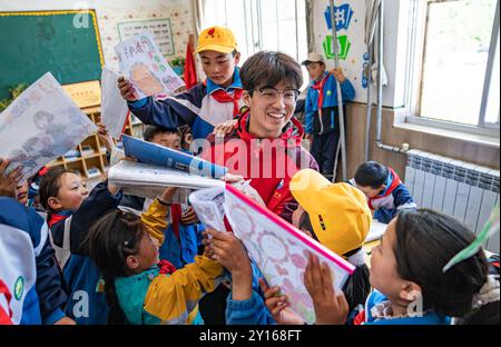 (240905) -- NYINGCHI, 5 septembre 2024 (Xinhua) -- Un enseignant bénévole de l'Université normale de Lingnan dans le Guangdong interagit avec des étudiants de l'école primaire centrale du canton de Nyangpo, comté de Gongbo'Gyamda, ville de Nyingchi, région autonome de Xizang au sud-ouest de la Chine, 3 septembre 2024. Située à une altitude de près de 4 000 mètres, l'école primaire a été confrontée à de graves difficultés lors de sa création en 1994, avec des installations pédagogiques médiocres et une rotation des enseignants en hausse. Pour aider à résoudre ces problèmes et améliorer l'éducation locale, des écoles de la ville de Zhongshan, province du Guangdong, au sud de la Chine, ont organisé p Banque D'Images