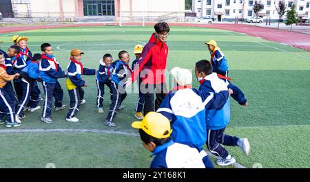 (240905) -- NYINGCHI, 5 septembre 2024 (Xinhua) -- Un enseignant bénévole de l'Université normale de Lingnan dans le Guangdong joue avec des étudiants de l'école primaire centrale du canton de Nyangpo, comté de Gongbo'Gyamda, ville de Nyingchi, région autonome de Xizang au sud-ouest de la Chine, 3 septembre 2024. Située à une altitude de près de 4 000 mètres, l'école primaire a été confrontée à de graves difficultés lors de sa création en 1994, avec des installations pédagogiques médiocres et une rotation des enseignants en hausse. Pour aider à résoudre ces problèmes et améliorer l'éducation locale, des écoles de la ville de Zhongshan, dans la province du Guangdong au sud de la Chine, ont organisé paire Banque D'Images