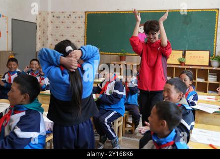 (240905) -- NYINGCHI, 5 septembre 2024 (Xinhua) -- Un enseignant bénévole de l'Université normale de Lingnan dans le Guangdong interagit avec des étudiants de l'école primaire centrale du canton de Nyangpo, comté de Gongbo'Gyamda, ville de Nyingchi, région autonome de Xizang au sud-ouest de la Chine, 3 septembre 2024. Située à une altitude de près de 4 000 mètres, l'école primaire a été confrontée à de graves difficultés lors de sa création en 1994, avec des installations pédagogiques médiocres et une rotation des enseignants en hausse. Pour aider à résoudre ces problèmes et améliorer l'éducation locale, des écoles de la ville de Zhongshan, province du Guangdong, au sud de la Chine, ont organisé p Banque D'Images