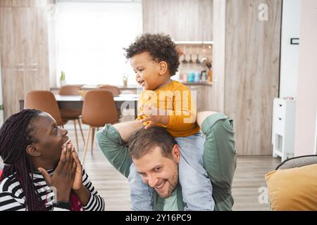 Famille multiraciale profitant de moments ludiques à l'intérieur dans la maison Banque D'Images