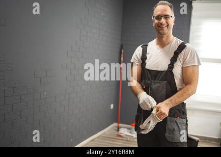 L'homme met des gants de protection Banque D'Images