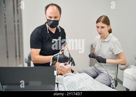 Jeune assistant aide le dentiste avec le travail Banque D'Images