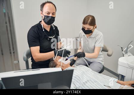 Équipe de dentistes au travail dans une clinique Banque D'Images