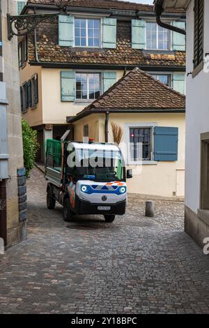 03-09-2024 Zurich, Suisse. Petit camion utilitaire électrique micro dans une rue étroite dans la vieille ville. Concept de collecte des ordures, journée ensoleillée d'été, n Banque D'Images