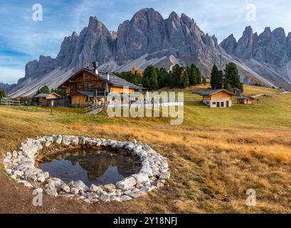 Vue panoramique de Geisler Alm Rifugio delle Odle en face des montagnes dolomites et reflet dans l'eau d'un étang, Tyrol du Sud, Dolomites, Italie Banque D'Images