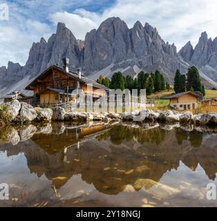 Vue panoramique de Geisler Alm Rifugio delle Odle en face des montagnes dolomites et reflet dans l'eau d'un étang, Tyrol du Sud, Dolomites, Italie Banque D'Images