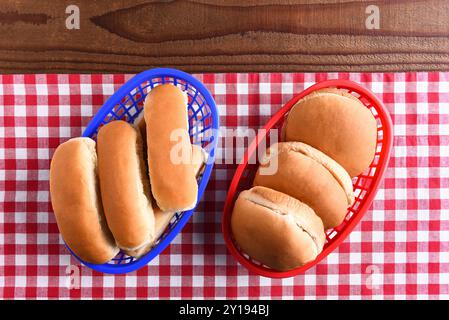 Pains hamburger et hot dog dans des paniers en plastique sur une table de pique-nique. l'image à thème rouge blanc et bleu convient aux thèmes patriotiques de vacances. Banque D'Images