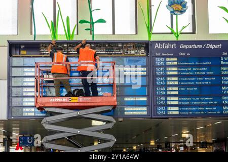 Techniciens travaillant sur un tableau d'information électronique, tableau d'affichage pour les liaisons ferroviaires à la gare centrale de Düsseldorf, NRW, Allemagne Banque D'Images