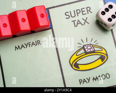 Gros plan de la propriété chère et riche taux plus élevé Super Tax Square sur le jeu de société Monopoly Banque D'Images