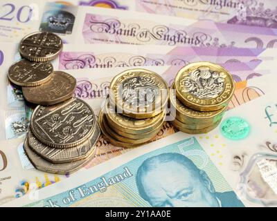 Gros plan des pièces de la livre britannique reposant sur des billets de la livre sterling argent comptant, Royaume-Uni Banque D'Images