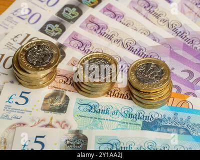 Gros plan des pièces de la livre britannique reposant sur des billets de la livre sterling argent comptant, Royaume-Uni Banque D'Images