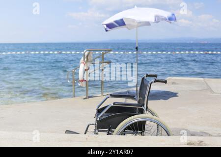 Fauteuil roulant sur une plage accessible pour le transport des personnes handicapées dans l'eau Banque D'Images