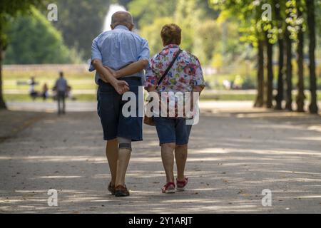 Le Jaegerhofallee dans le Hofgarten le parc municipal central de Duesseldorf, vue sur la fontaine Jroener Jong, dans l'étang rond, couple senior, No Banque D'Images