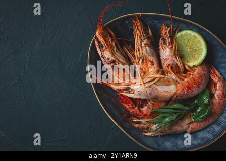 Langoustines, australiennes, fraîchement congelées sur glace, vue de dessus, citron vert et vert Banque D'Images