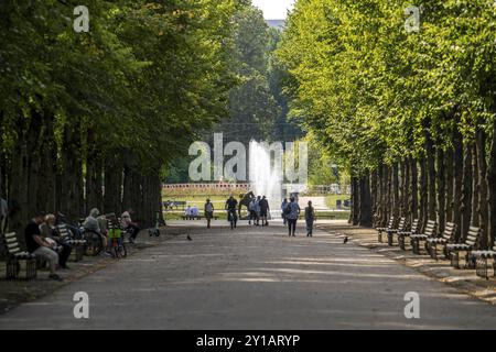 Le Jaegerhofallee dans le Hofgarten, le parc municipal central de Duesseldorf, vue sur la fontaine Jroener Jong dans l'étang rond, Rhénanie du Nord-Westp Banque D'Images