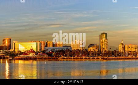 La ligne d'horizon de long Beach brille sous la lumière de l'heure d'or, avec les eaux calmes de l'océan Pacifique reflétant l'architecture moderne et l'histoire de la ville Banque D'Images