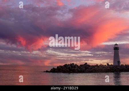 Ciel crépusculaire animé au-dessus du phare de Breakwater (Walton) via Seabright Beach. Santa Cruz, Californie, États-Unis. Banque D'Images