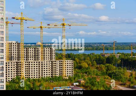 De multiples grues sont activement engagées dans la construction près du front de mer, illustrant la croissance dynamique du développement urbain moderne. Banque D'Images