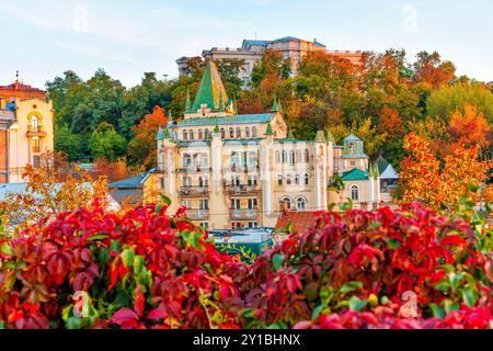 Kiev, Ukraine - 14 octobre 2023 : bâtiments colorés surplombant le feuillage d'automne le long de la descente Andriivskyi à Kiev. Banque D'Images