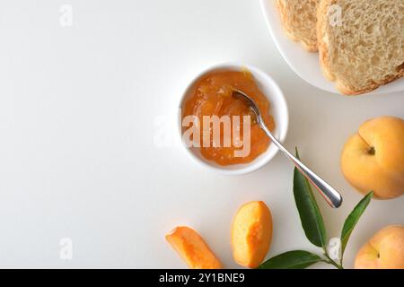 Banc de cuisine avec petit déjeuner préparé avec confiture de pêches et pain grillé sur l'assiette et des fruits autour. Vue de dessus. Banque D'Images