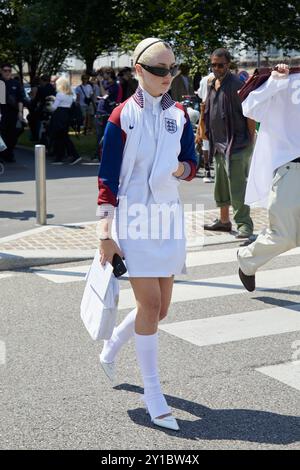 MILAN, ITALIE - 16 JUIN 2024 : femme avec un maillot Nike England et des chaussures Prada blanches avant le défilé Prada, le style Street week de Milan Banque D'Images