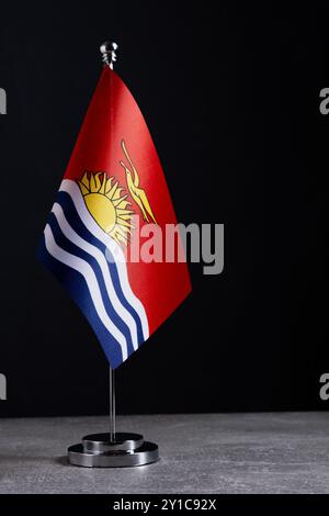 Drapeau Kiribati sur mât de drapeau en métal sur fond noir Banque D'Images